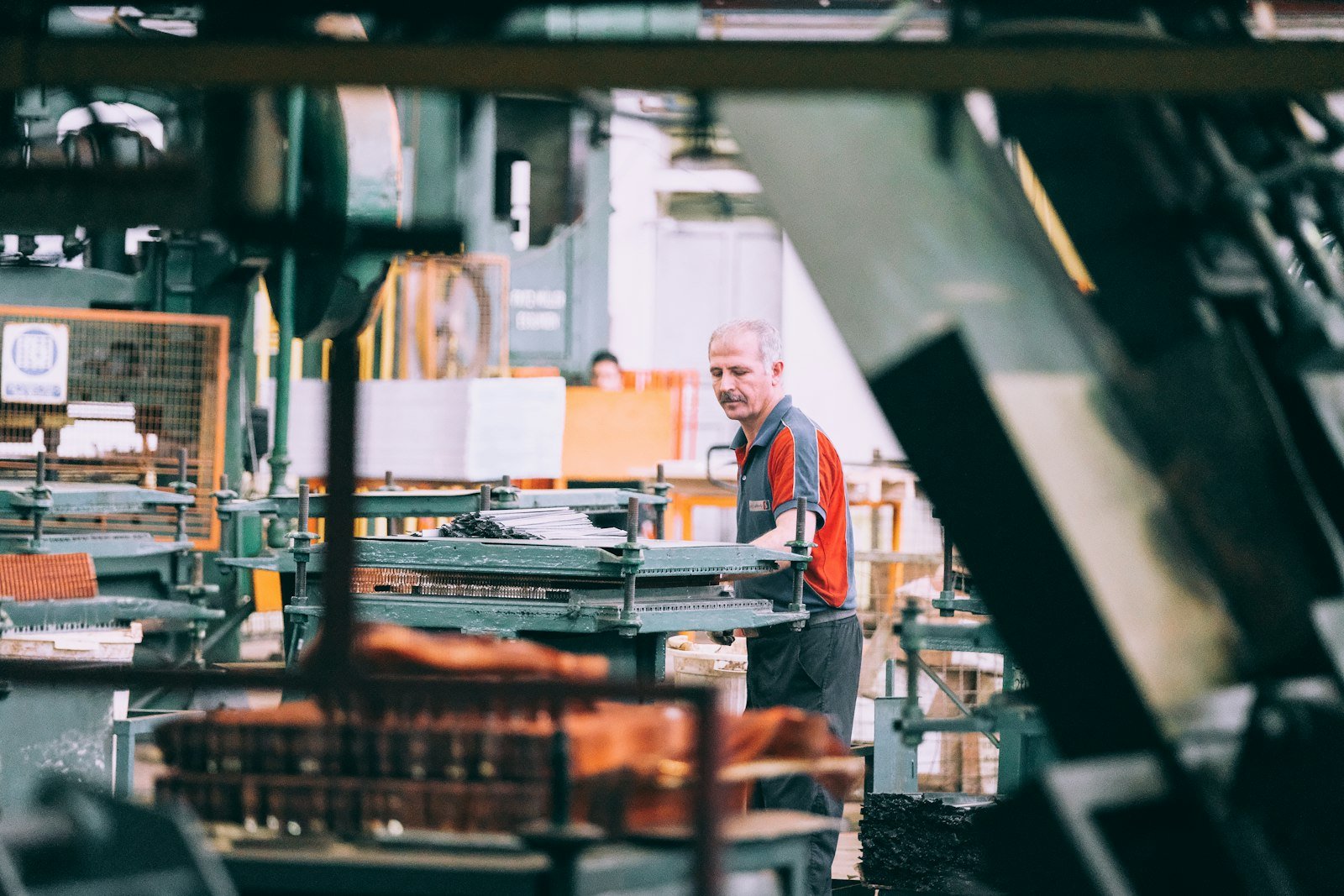 An operator working at industrial machinery on a factory floor